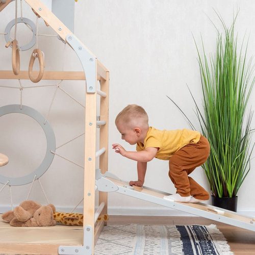 wooden climbing playhouse side view boy playing ramp climbing