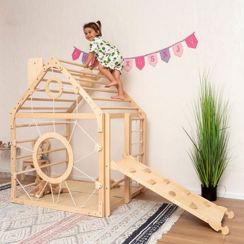 wooden climbing playhouse side view girl playing on top